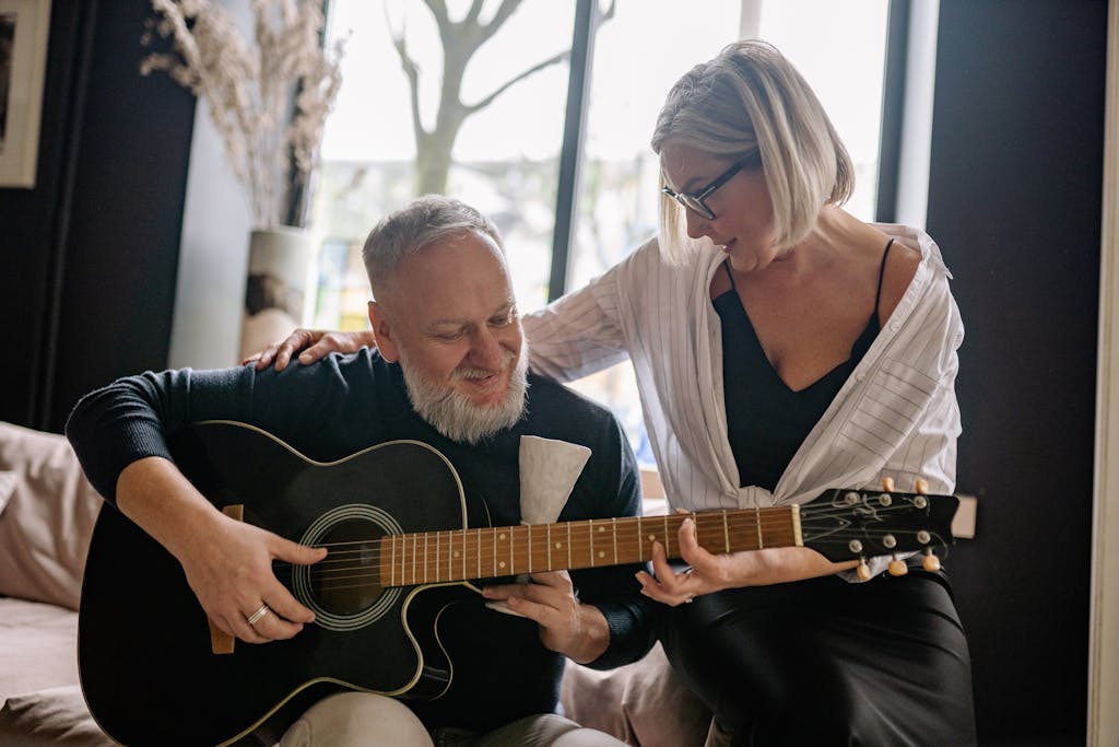 An Elderly Couple Playing the Guitar Together